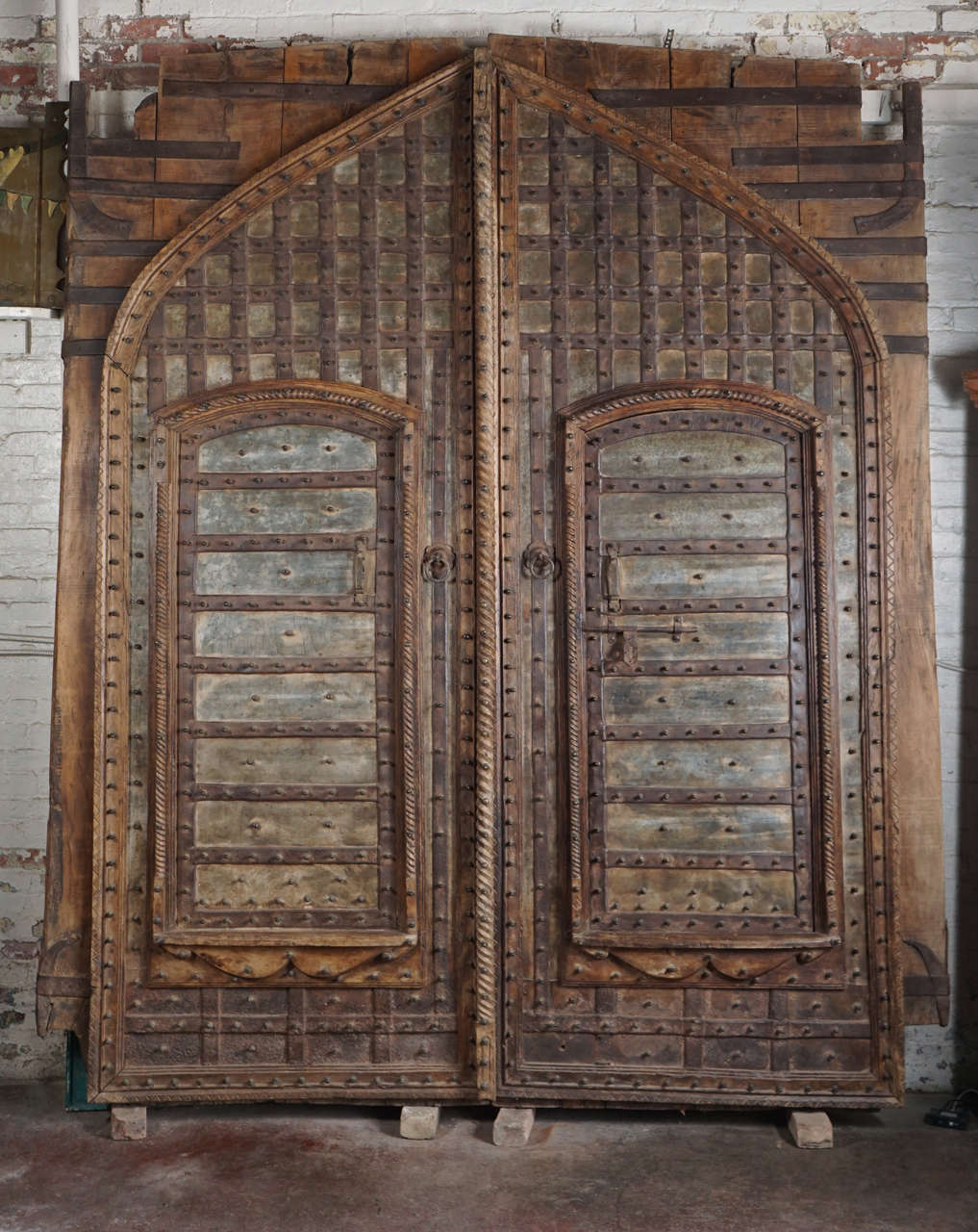 Monumental pair of hand carved teakwood garden doors riveted with iron pegs.