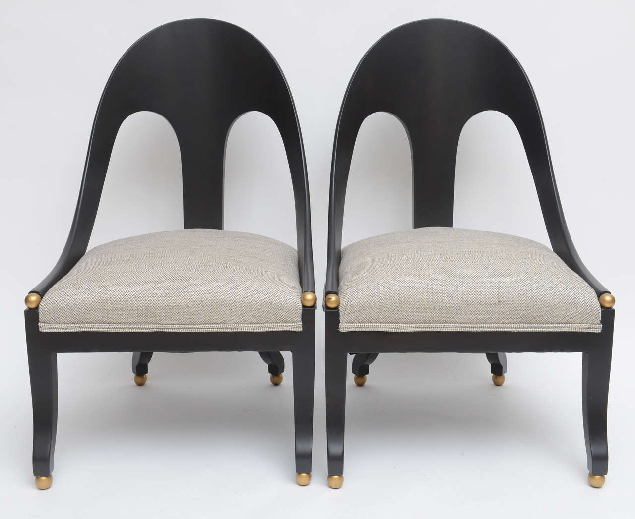 Pair of Michael Taylor for Baker spoon back lounge chairs.
Mahogany dowel jointed kiln dried base, newly refinished in an ebonized satin lacquer finish, with gold finial ball feet.
Finial ball details to the end of the armrests.
Newly