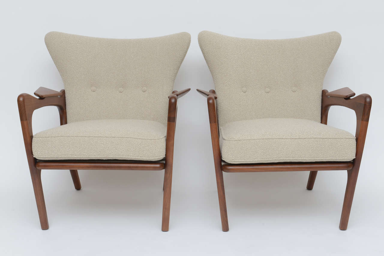 Our favorite Pearsall design! Walnut wing chairs upholstered in a neutral cream and tan bouclé́.