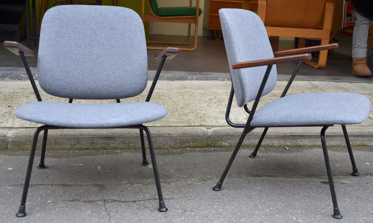 Two 1950s armchairs by W. H. Gispen Edition Kembo, with black metal structure and wooden armrests; reupholstered in gray woolen fabric.