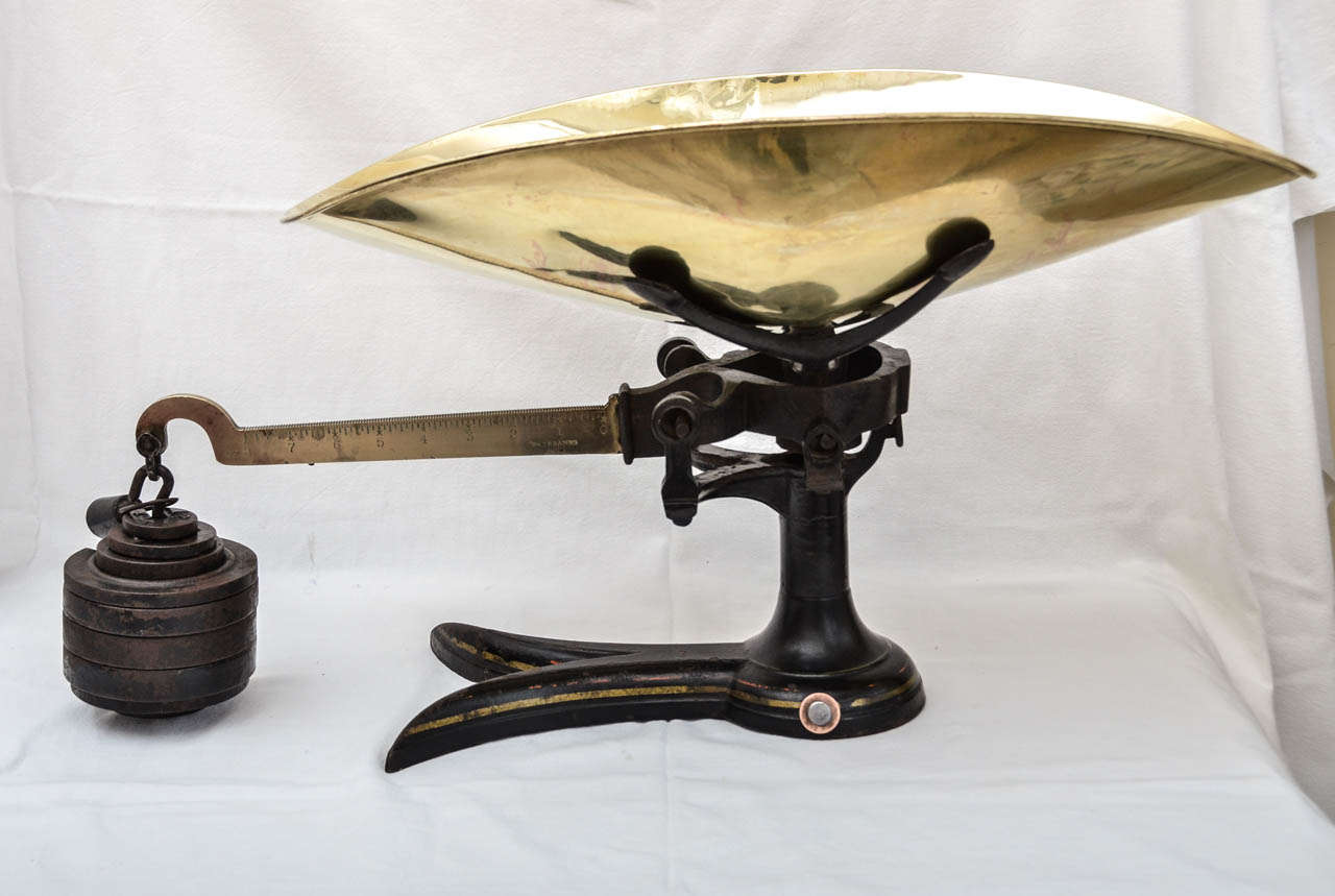 American 19th Century Fairbanks Scale With Brass Scoop Shaped Tray & Brass Crossbeam From Which Are Suspended Stacked Circular Weights.Weights are as follows: 1/ 2oz, 1/ 4oz., 2/ 2.5 lbs., 1/1lb., 1/ .5 lbs..The Base Is Black Enameled Painted With