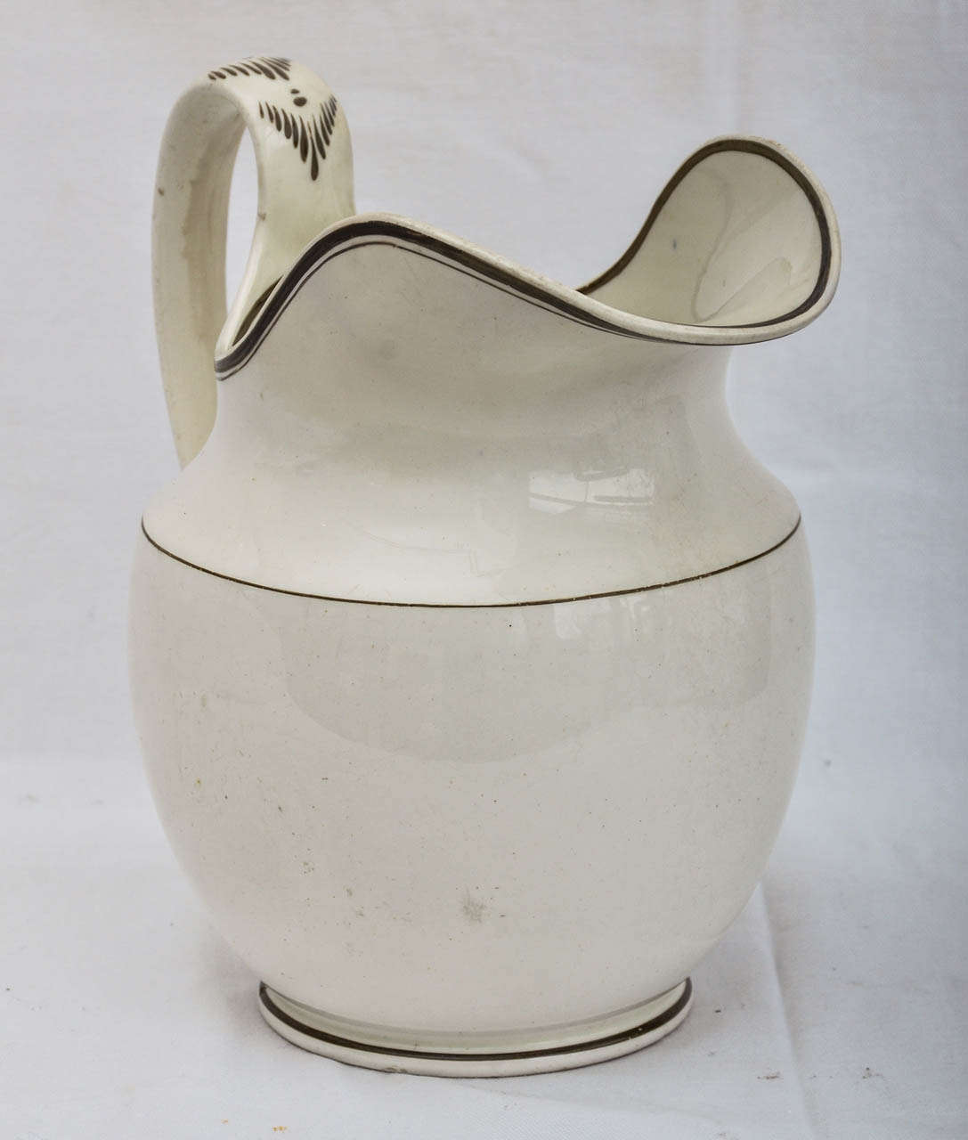 Large 19Th Cent. English Creamware Jug With Dark Brown-Green Pin Stripping To Lip - Base and Three Quarters Up The Body OF The Jug. The Handle Has A Painted Chevron Pattern Decorating. Most Likely Was Used For Cider, Ale Or Milk. The Jug Is In