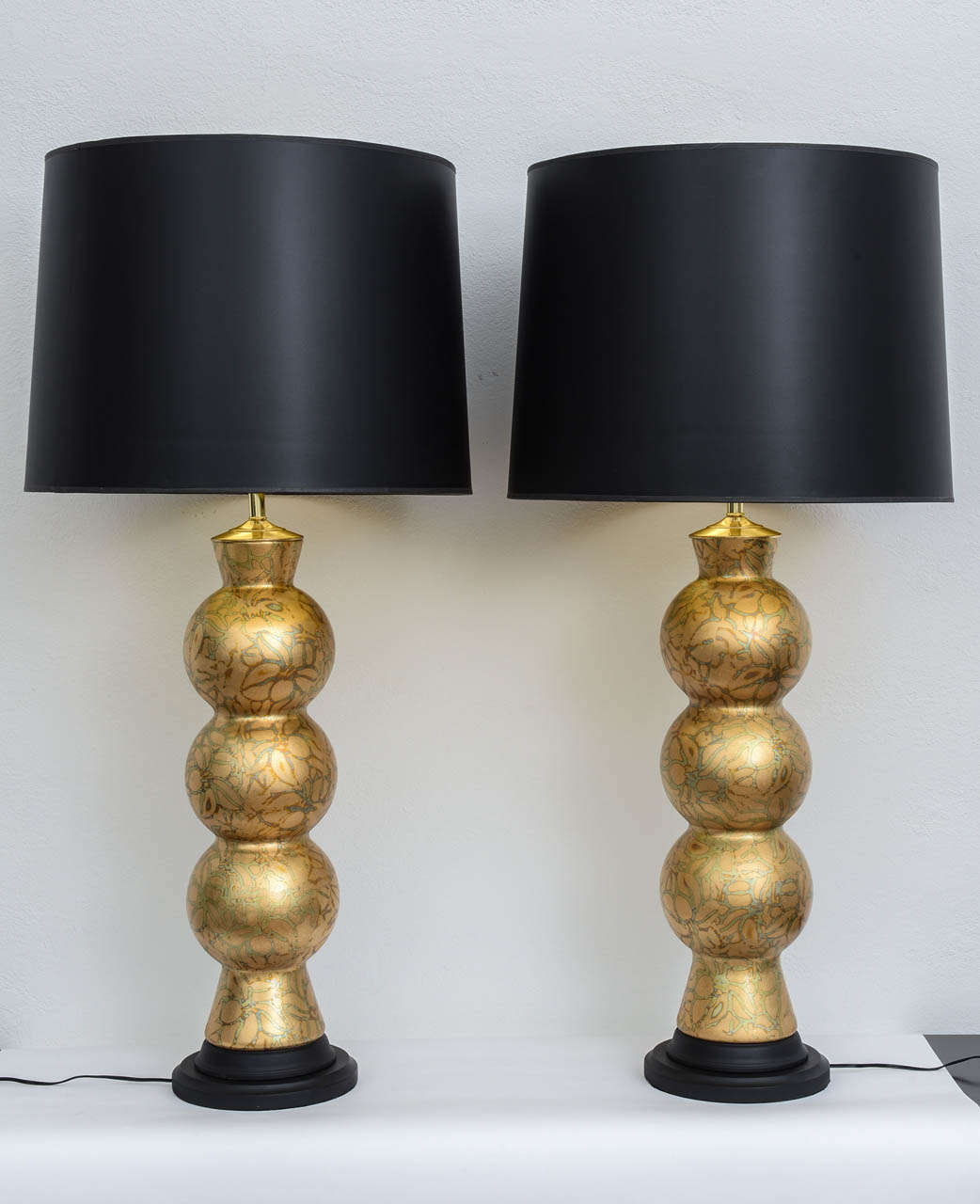 Pair of stacked glass globe lamps covered entirely with hand placed variegated gold leaf. The matte black wood bases match the matte black shades. Newly rewired and sold as a pair.