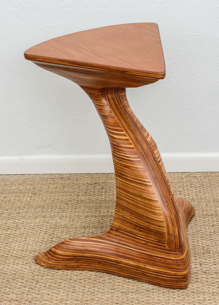 Sculptural pedestal table fashioned of layers of various woods with an oak top surface. Newly refinished with a clear top coat of satin lacquer for protection. Uniquely designed and sculpturally functional.