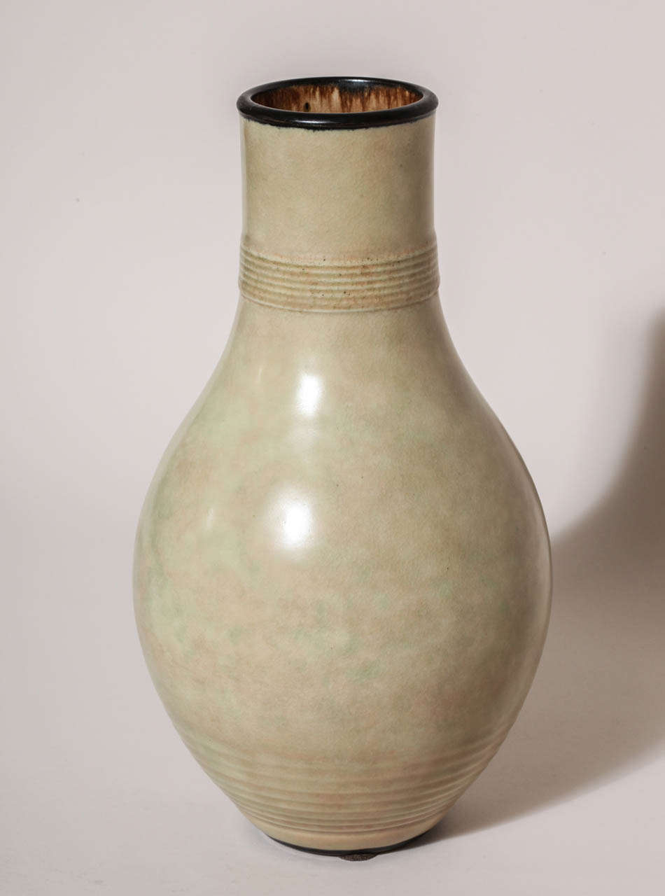 This ivory colored vase has subtle green and pink undertones, multiple rings around the neck and foot and a black enameled rim and foot.
Signed: EDecoeur incised 

Other E´mile Decoeur vases available.