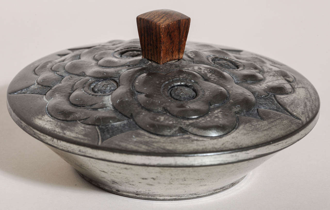 Hand-wrought dinanderie pewter covered box with design of flowers and with rosewood handle.

Signed: 'R. Delavan' on body.
Stamped: 'ETAIN GARANTI'

Variety of other Rene Delavan pieces available.

(Price shown is reduced price, no further trade