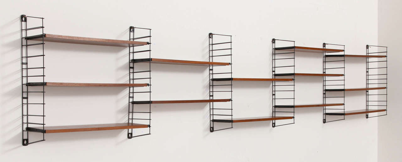 A metal and teak shelving unit from the 1950s, designed by D. Dekker for Tomado. This shelving unit consists of 18 teak shelves and eight uprights. The uprights are 69 and 44 cm high, the shelves are 65 cm wide and 19 cm deep. Marked and in a very