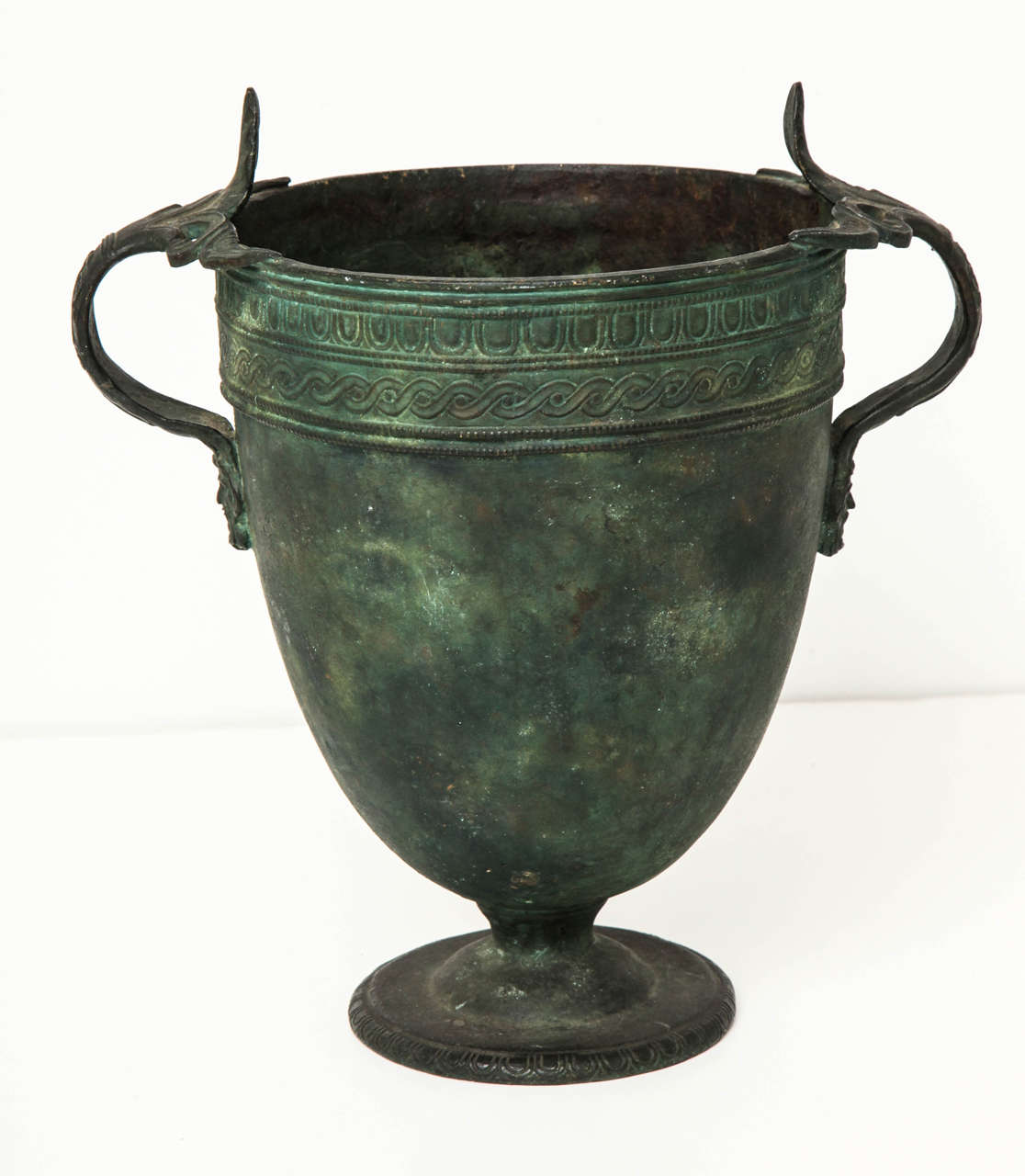 A 19th century Italian bronze vase after The Antique
Naples, circa 1870, probably Fonderia Chiurazzi

Decorated with banded egg-and-dart and Vitruvian scroll patterns with foliate acanthus-leaf handles terminating in bearded masks. A Grand Tour