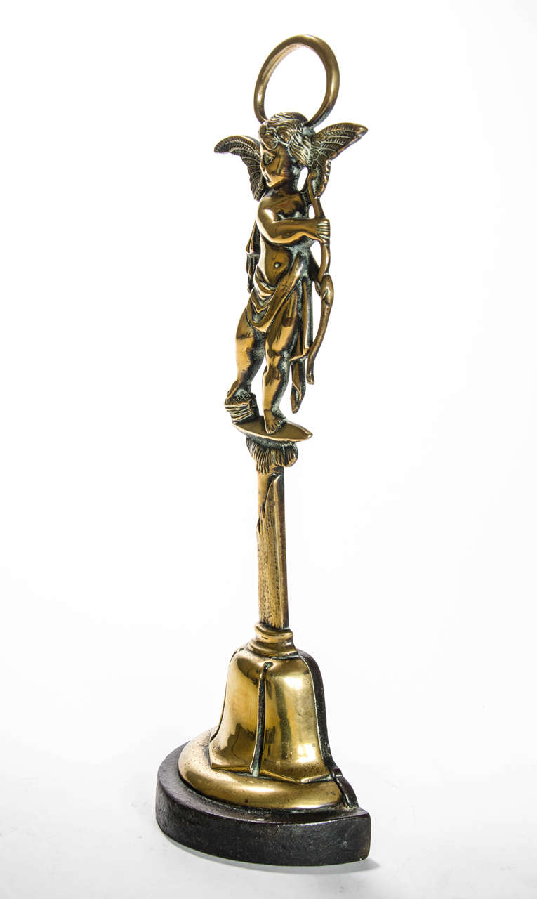 A cupid Door stop cast in the form of a winged cupid holding a bow: Victorian circa 1860.