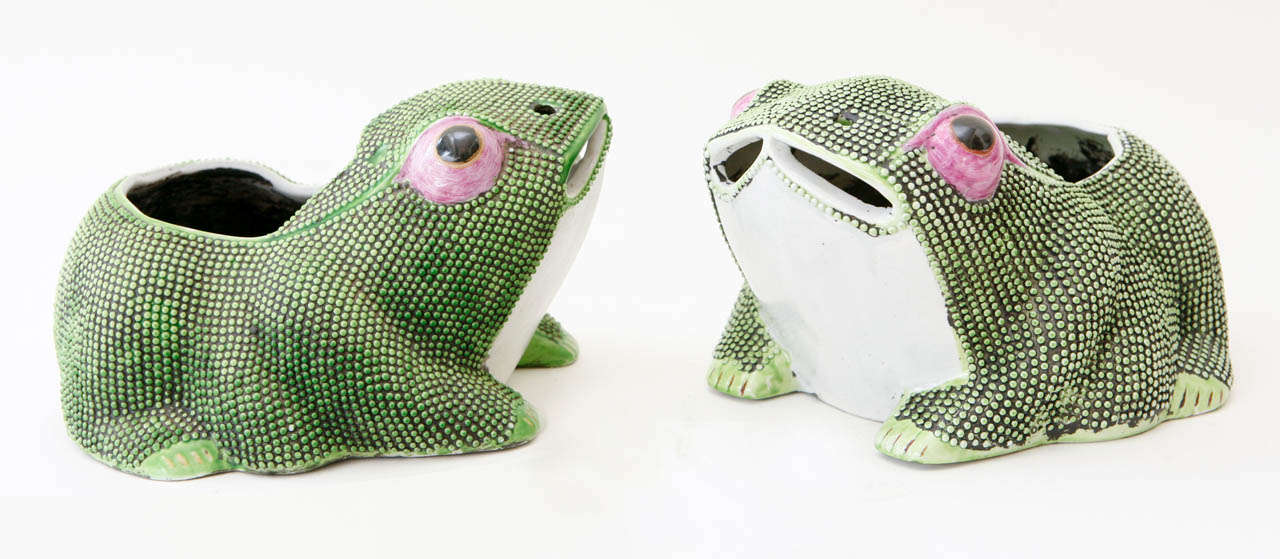A whimsical pair of 19th century Chinese porcelain frog planters with textured bodies in a bright spring green glaze over black with lavender eyes. These planters were a staple of Tony Duquette interiors and are becoming harder to find in this kind