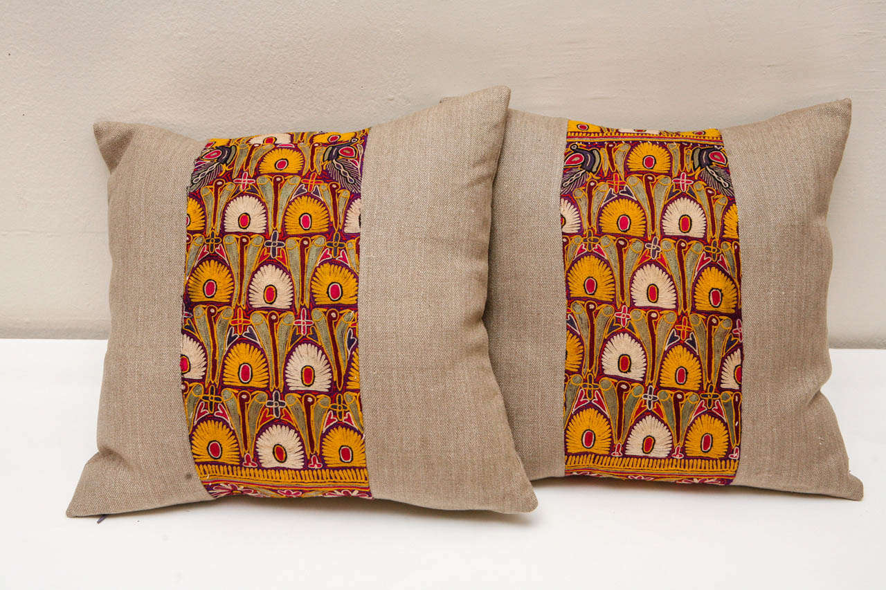 Linen pillows with intricately embroidered silk on silk Choli panels in marigold, ivory, and shades of purple. Indian. Taupe colored linen backing, hidden zipper enclosure, feather & down filling. Priced individually at $850 each.