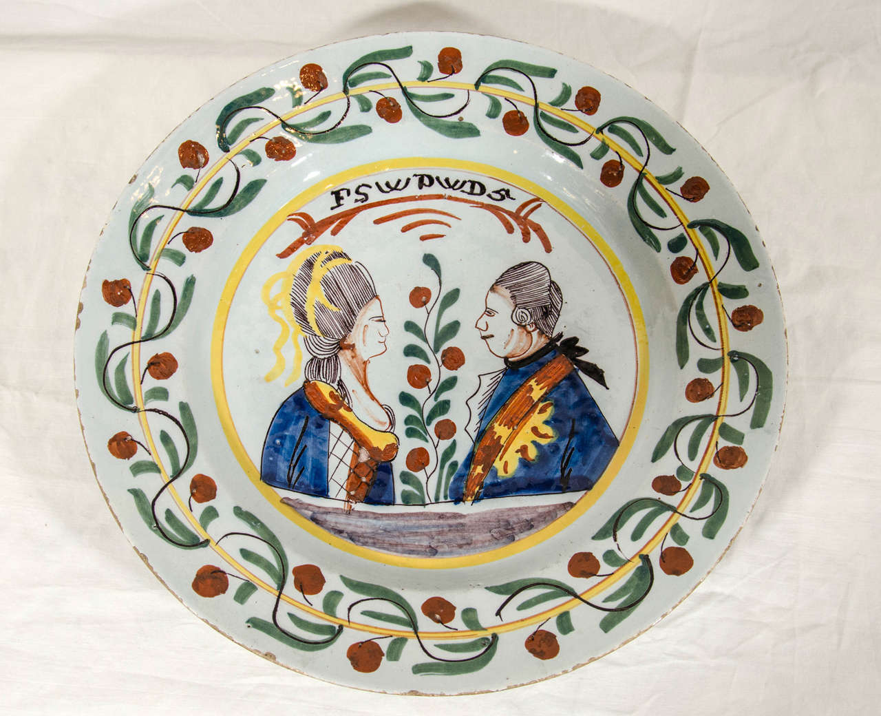 An 18th century royal commemorative Dutch delft charger in favor of the House of Orange. The center in the form of a medallion with portraits in profile depicting the marriage of Prince William V of Orange and Princess Frederica Sophia Wilhelmina of