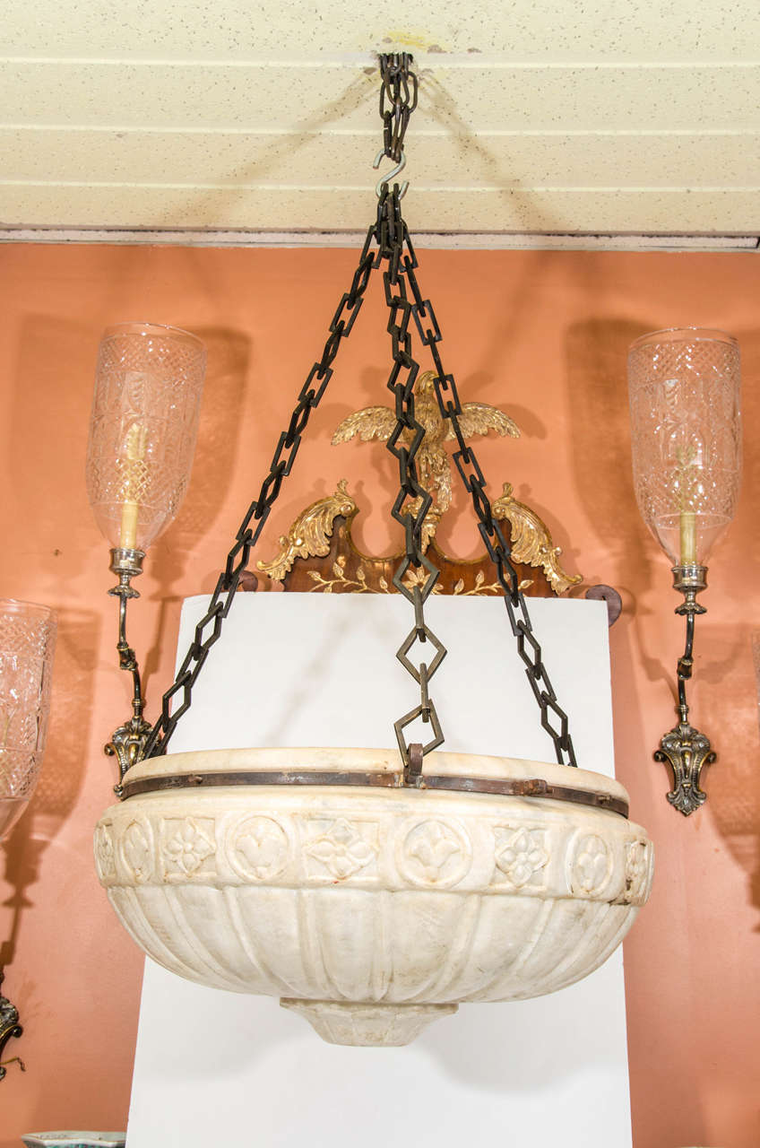 A large 'Grand Tour' style carved marble pendant light or jardinière suspended on iron diamond strap work chain.