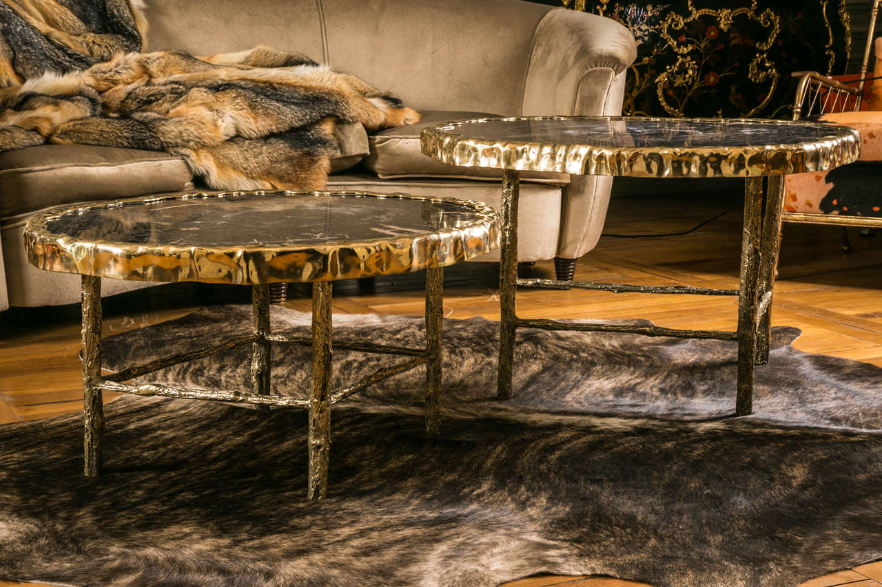 Pair of black petrified wood coffee tables, creation Galerie Glustin, limited pieces, bronze feet and frames.
Dimensions for one table 93 x 82 x H 52cm, 
the other one being 78 x 73 x H 42 cm