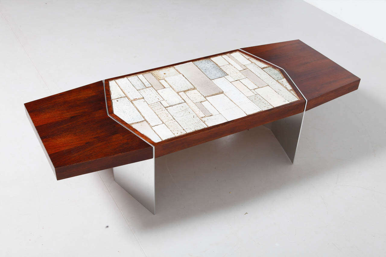 Rosewood low coffeetable designed by Amphora Belgium.
A modernist cocktail table with a top composed of hand thrown glazed tiles in shades of cream and white in a variety of square and rectangular shapes and sizes. The table was produced by the