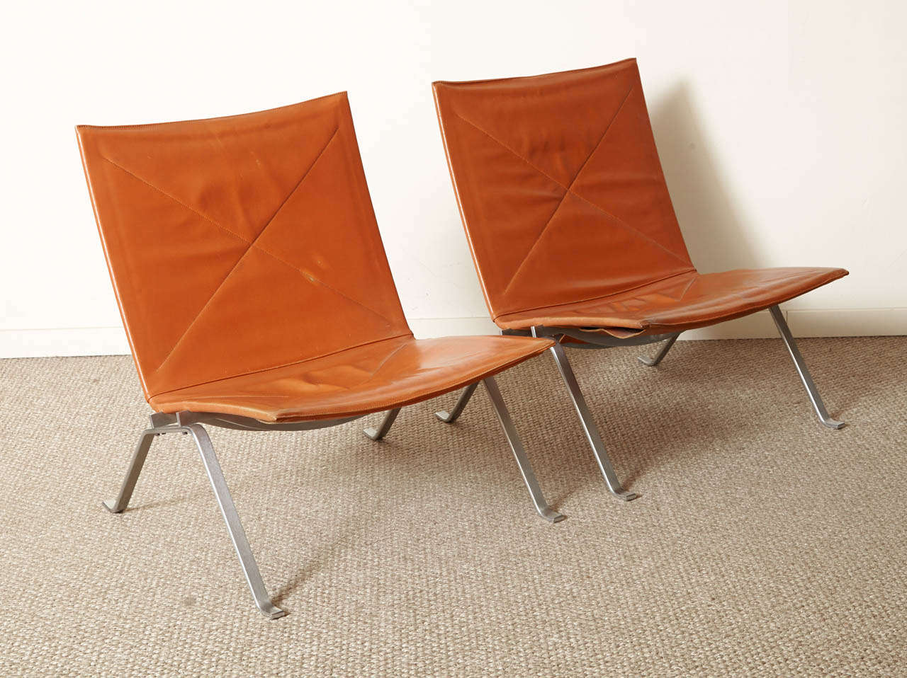 A pair of 1960 loungechairs by Poul Kjaerholm, with the original stamp by Kold Christensen.
