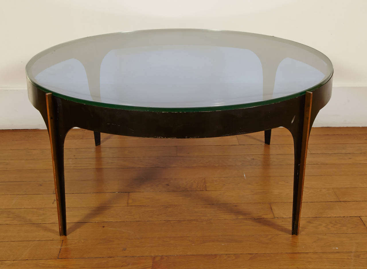 Exceptional coffee table with a curved blue under top and flat clear glass top, by Fontana Arte, Italie, circa 1950-55. 
Black metal base ornated on its four feet with straight gilt brass rods.
The upper glass top is resting on the top circle of