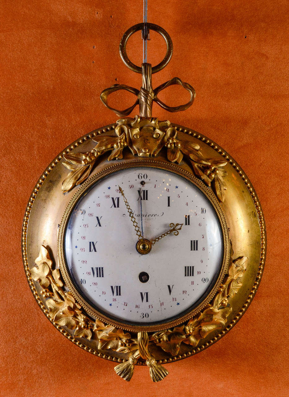 round ormolu clock supported by a node, decorated ivy leaves and laurel with a coat of arms in its center, signed by Manière  clockmaker in Paris