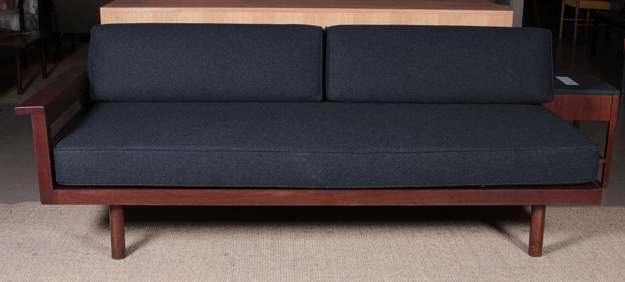 Beautiful walnut daybed with cane detail on the arm. Redone in a charcoal gray flannel. 1950's.