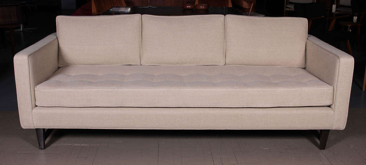 3 seat sofa with walnut frame and button tufted seat.