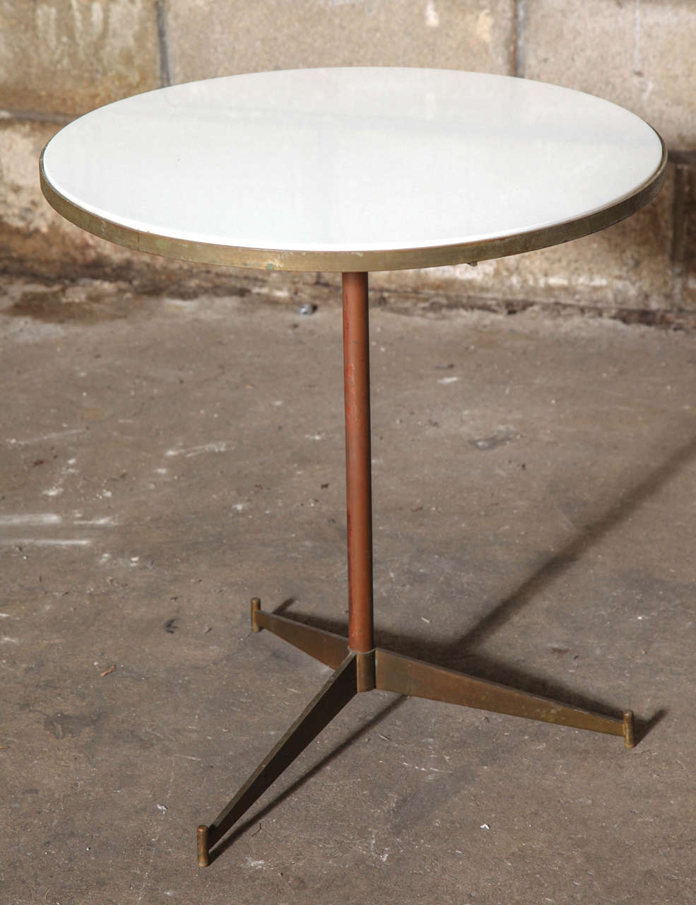 Handsome brass tripod table with white vitrolite top. All original condition. Coordinating sectional sofa from the same McCobb for Directional line also available. 