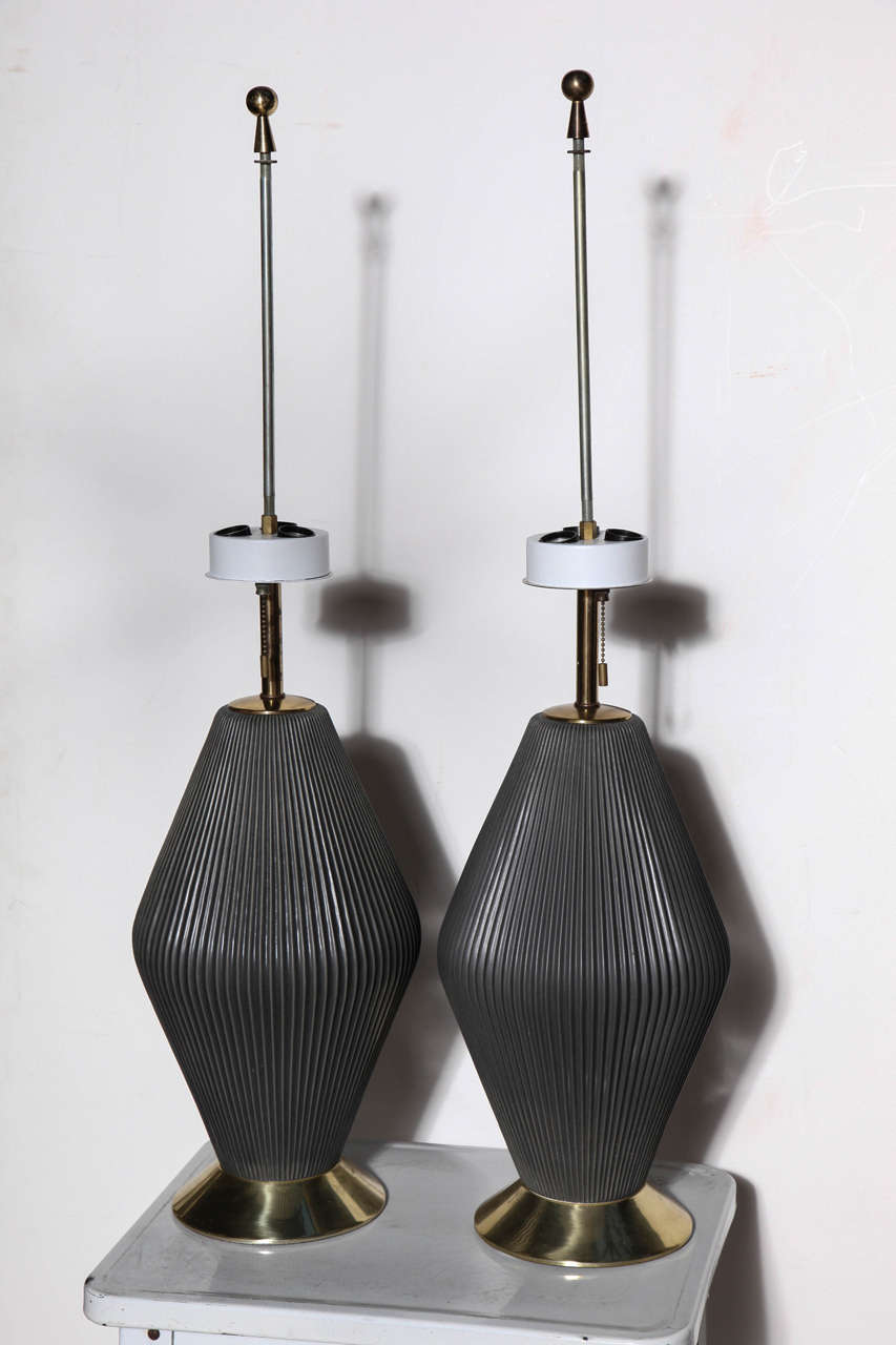 2 statuesque 1950's Gerald Thurston for Lightolier fluted hourglass Ceramic Lamps with Dark Gray satin glaze, Brass stem and beveled circular Brass base. White enameled Metal Triple socket. Rewired