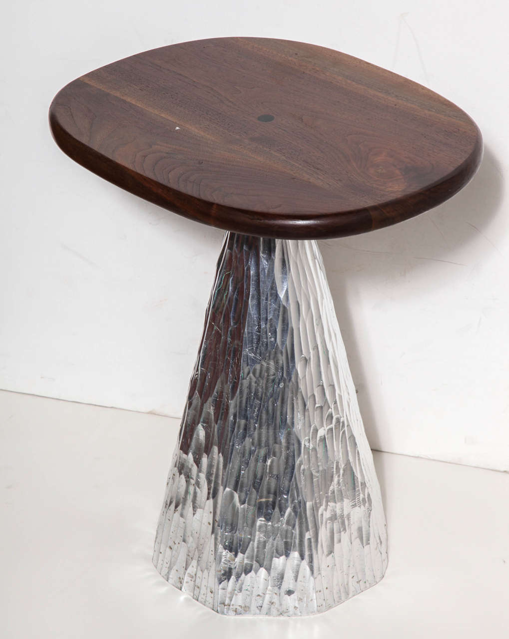 Phil Powell 2007 produced Occassional Table in lacquered Walnut with ebony button inlay on an ovoid Top and seated on a carved, chiseled triangular wooden base accentuated with Silver Leaf