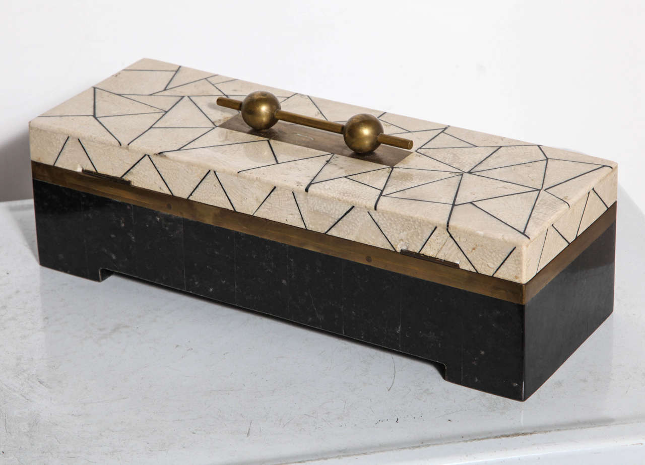 Late 1970s Maitland Smith decorative box. Featuring a rectangular shape accented with ivory cream and black delineated triangular tessellated marble, with hinged top, inset brass banding, black ebonized wood base, black velvet interior, with a brass