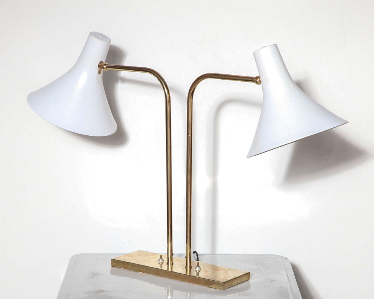 1950's Nessen Studios Brass and White Desk Lamp.  Featuring 2 White enameled adjustable Metal Shades, Brass arms and a rectangular Brass base.  Lamp design often attributed to Greta Von Nessen.  Two switches on Base.  Rewired