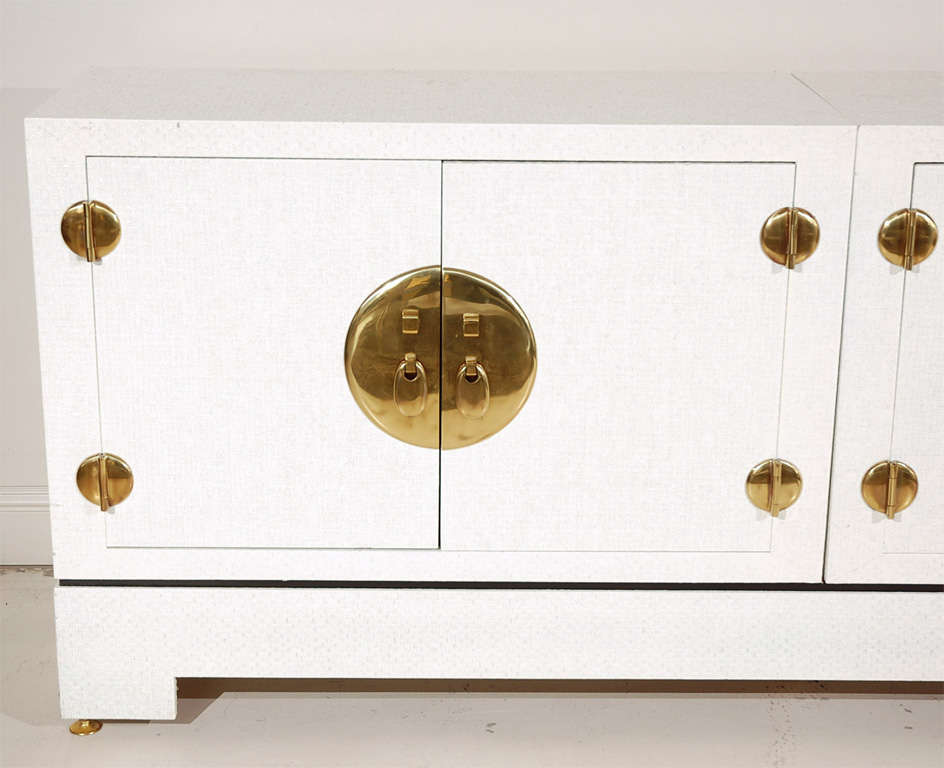 Lacquered grass cloth buffet with brass hardware in the style of Karl Springer.  Interior holds adjusable shelves.