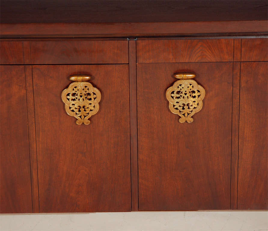 Large walnut sideboard with decorative Asian style hardware. Bert England for Johnson Furniture Company.  Cabinet has 4 doors, with two interior drawers, and 4 exterior upper drawers.