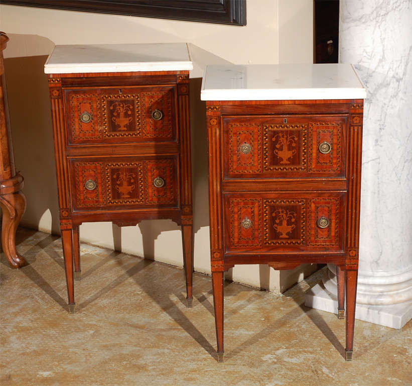 Two, inlaid, two-drawer commodini on tapered legs with white, Carrara marble tops from Naples.