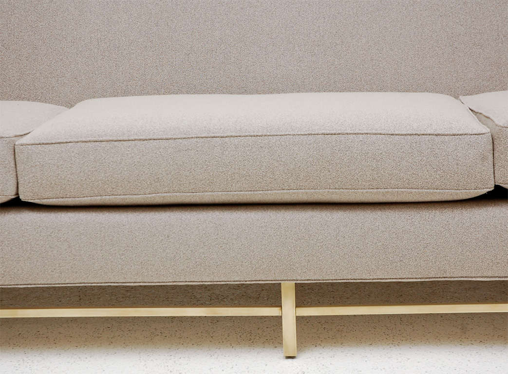 A Beautiful and chic 3 cushion  sofa newly reupholstered in a Donghia boucle   on a chic brass base.  Possibly Paul McCobb.