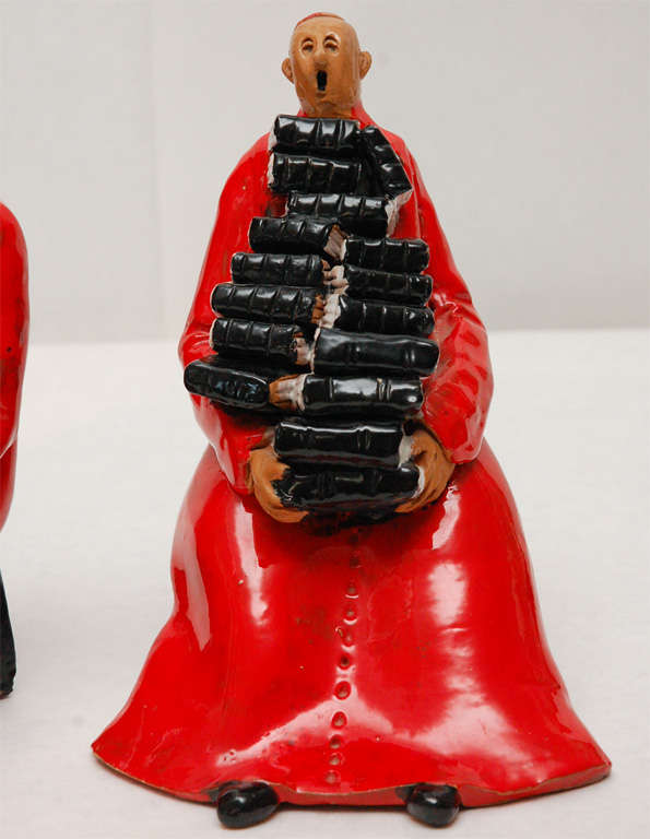 Wonderful and whimsical pair of bookends in the form of Cardinals holding stacks of black books.  These bookends have a wonderful sense of humor.  Both are signed and marked Italy on the interior of the stool.  There is an F carved in the clay.