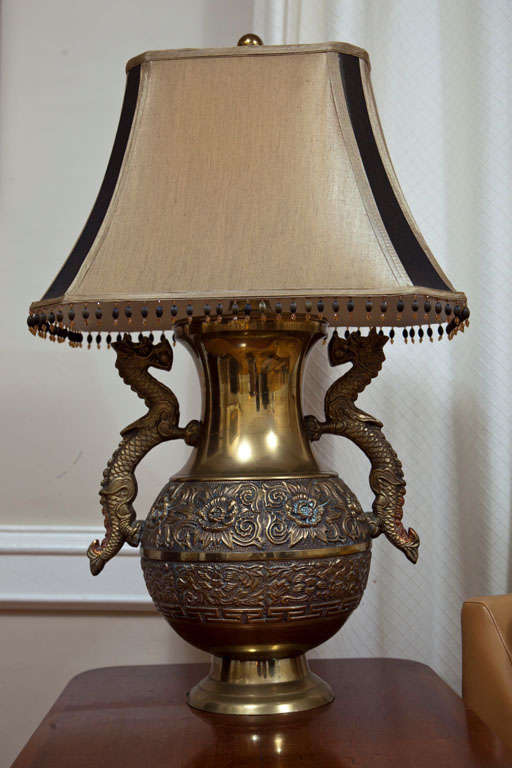 Here is a pair of lamps that one doesn't see every day! Cast of brass and finished with beautiful repoussé sunflowers, dragons and Greek key motifs, these exotic lamps have been topped with modern two-tone beaded shades, but look equally well with