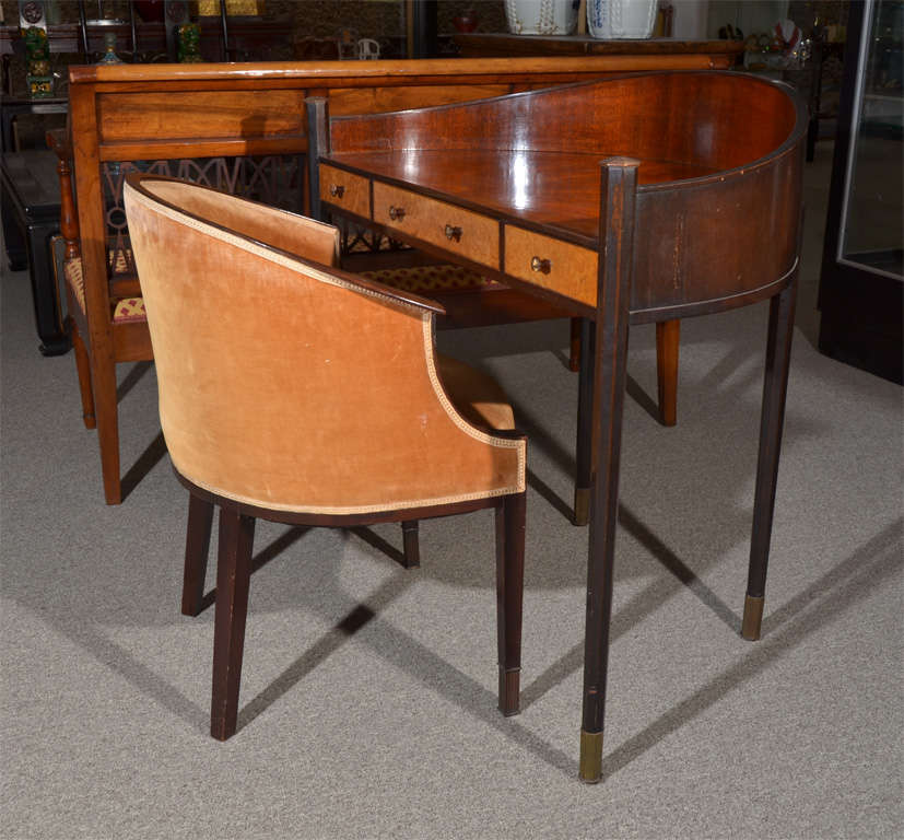 Diminutive American Art Deco hemispherical desk and muted gold velvet upholstered club chair en suite. The legs end in bronze sabots. Mahogany with sunburst design inlay on the writing surface, figured maple veneer on the drawer fronts. The drawer