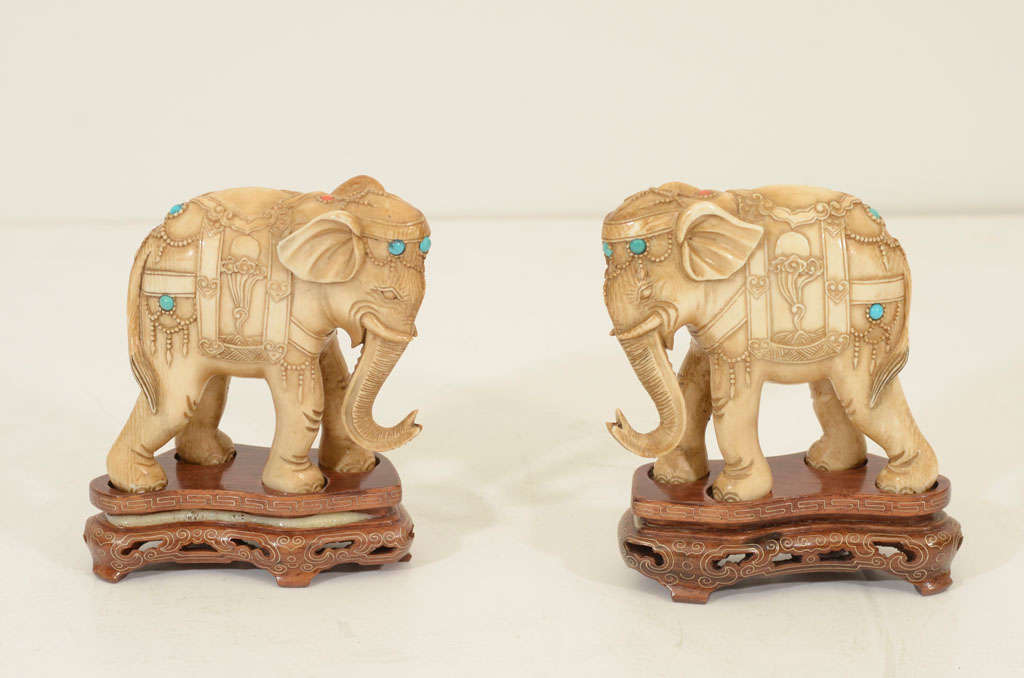 Pair of carved Chinese elephants on silver inlaid bases with turquoise insets