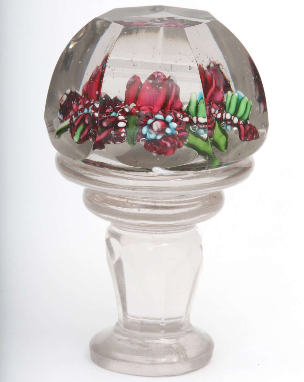 A rare Russian glass paperweight seal with a central red flower surrounded by five smaller flowers on top and clear glass lower section