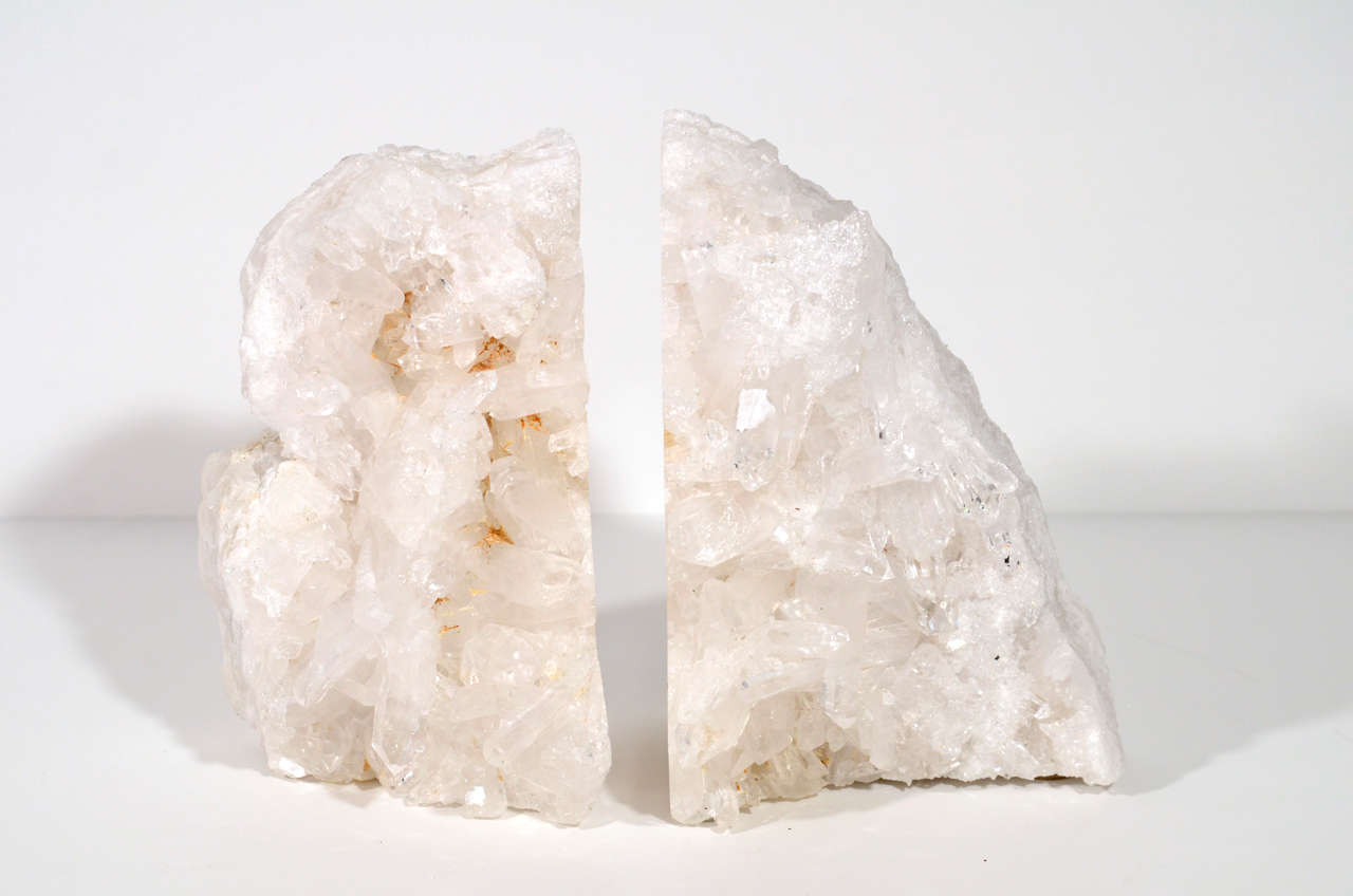 Stunning pair of natural crystal quartz bookends. The bookends are both rough and polished and feature large sparkling spiked crystals in variant hues of white. Together Bookends measure close to 10 inches in length. Make great decorative objects as