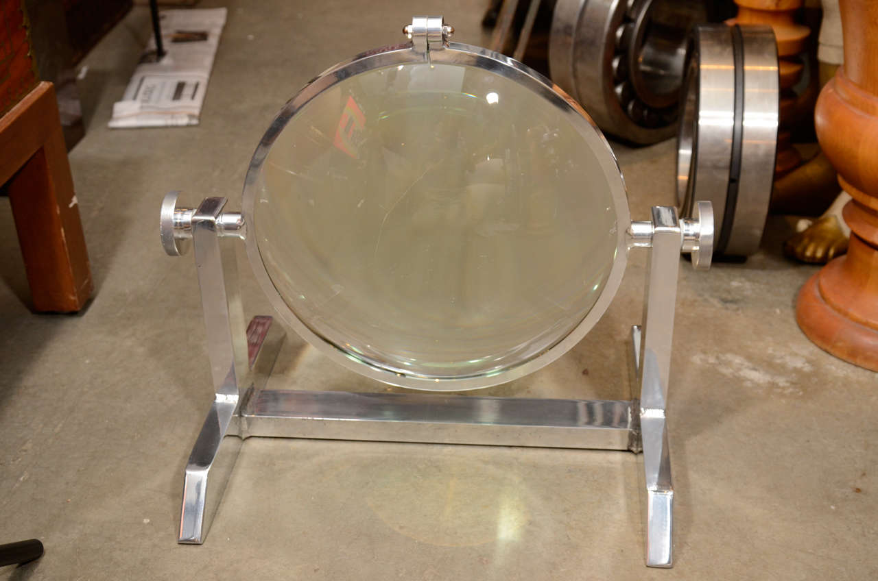 This is a monumental table top magnifier in a high polished aluminum adjustable stand. This was probably  used in an assembly line for up close soldering work etc. The possibilities of this as a decorative accessory are endless! The diameter of the