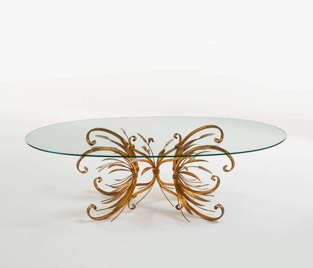 Cocktail table, glass, brass, France, ca. 1950

This wheat sheaf side or coffee table is decorative and has a French origin. The frame holds a patina to the brass surface and the silver finished wheat tops. The table comes  with an oval glass top.
