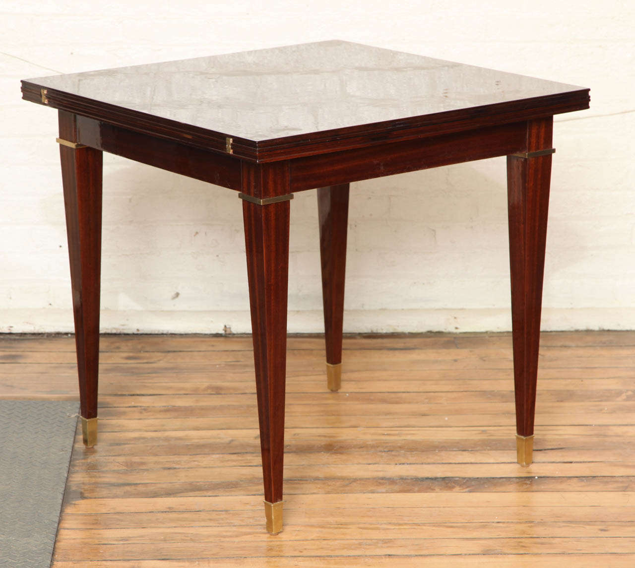 Elegant Art Deco expandable card table. 
When extended serves as a lovely dining table. Walnut and mahogany intarsia with bronze banding and sabots.