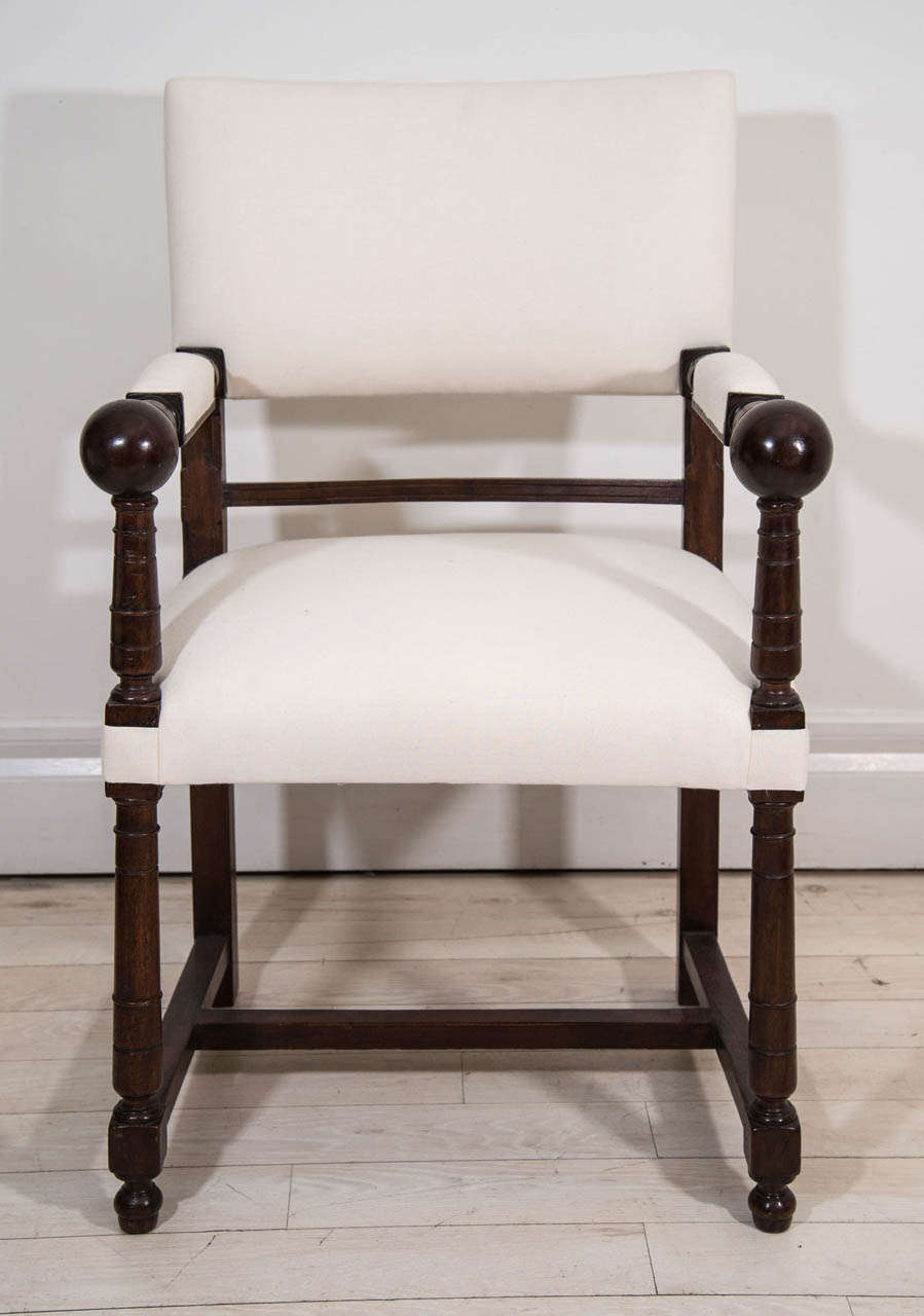 Pair of mahogany hall chairs with turned and upholstered arm rests, ending in ball details, and turned legs joined by stretchers