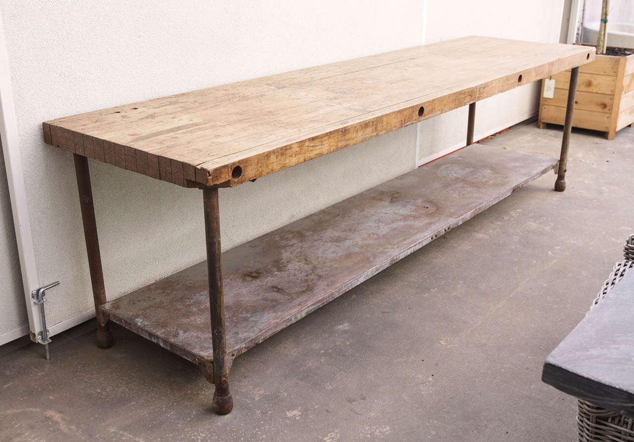 Industrial French artisan's shop table.
Beech top and iron base.
Original patina. 
Metal shelf.
Shelf measurements: 23