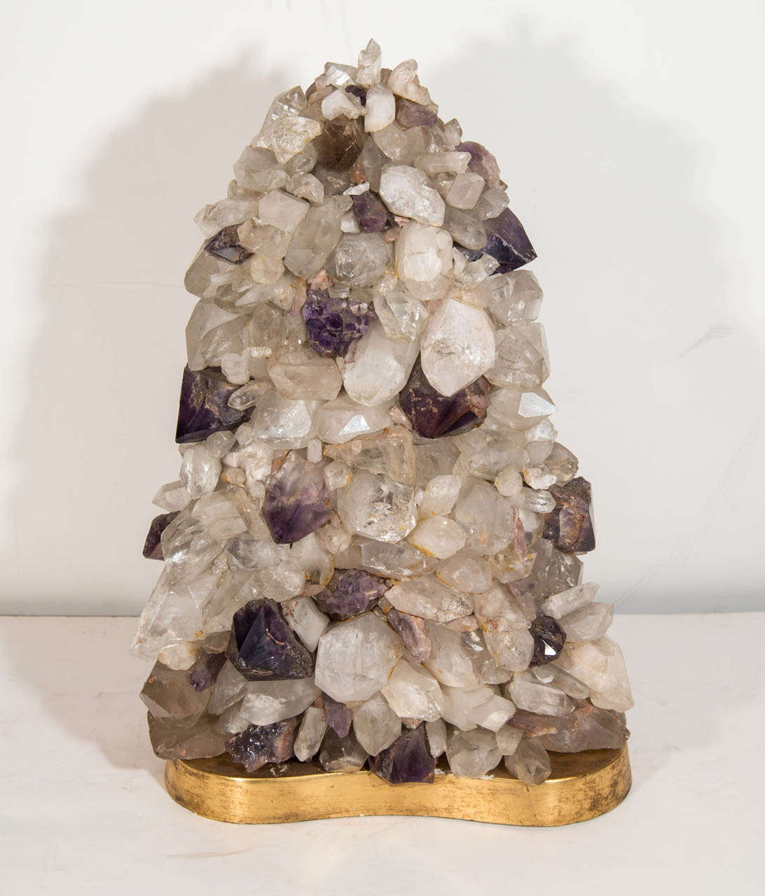 A large vintage rock crystal and amethyst quarts double-sided lamp on a giltwood base with an interior light.