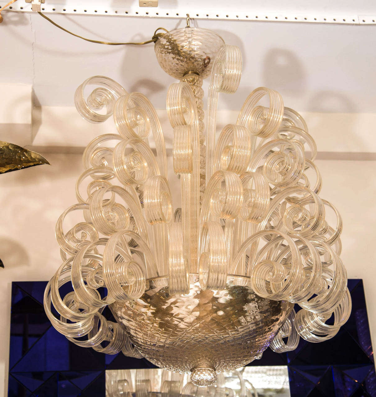Murano glass chandelier composed of clear glass scrolling elements and mercury glass bowl.