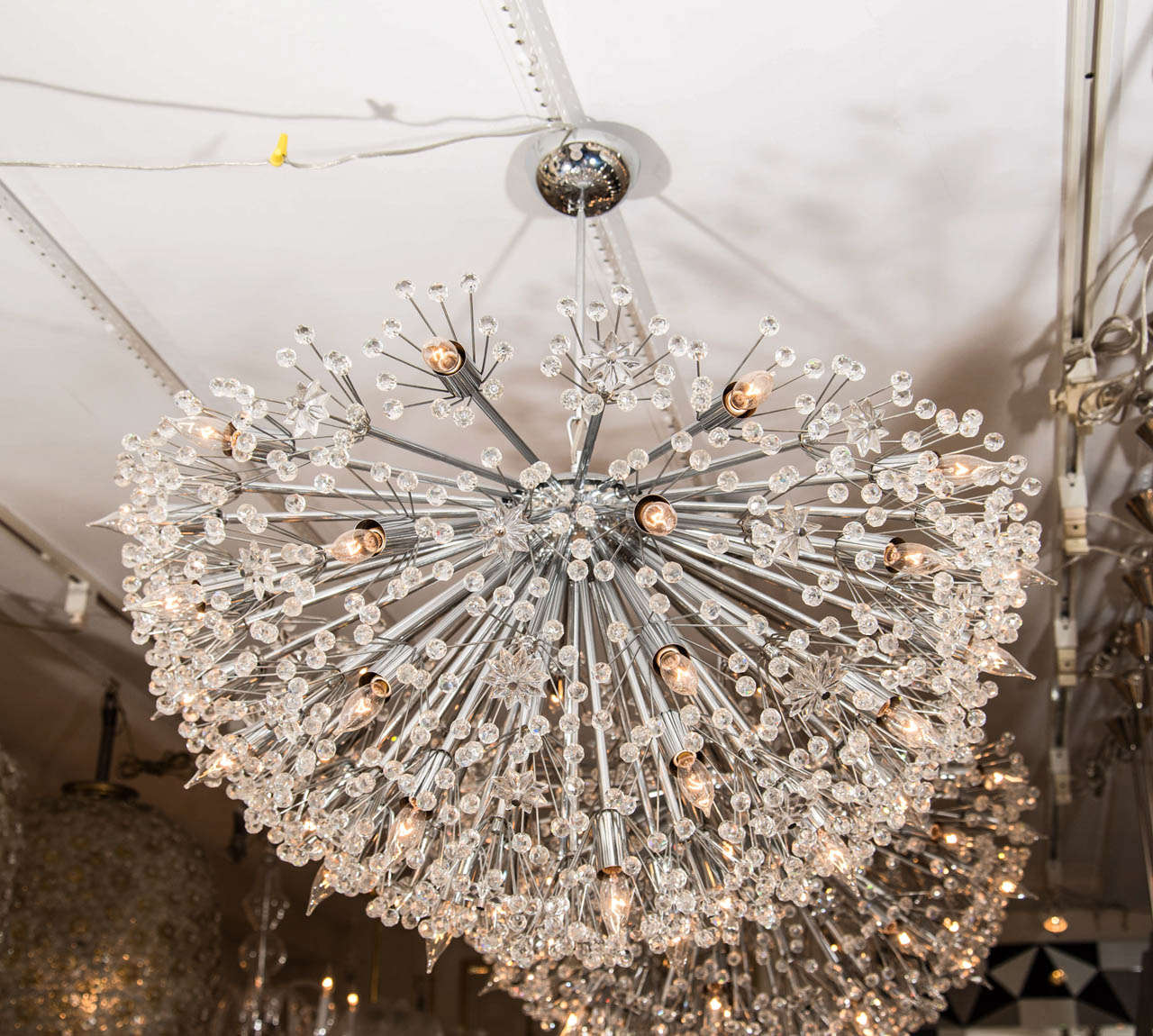 Monumental polished nickel half starburst chandeliers with glass stars and flowers by Emil Stejnar.
