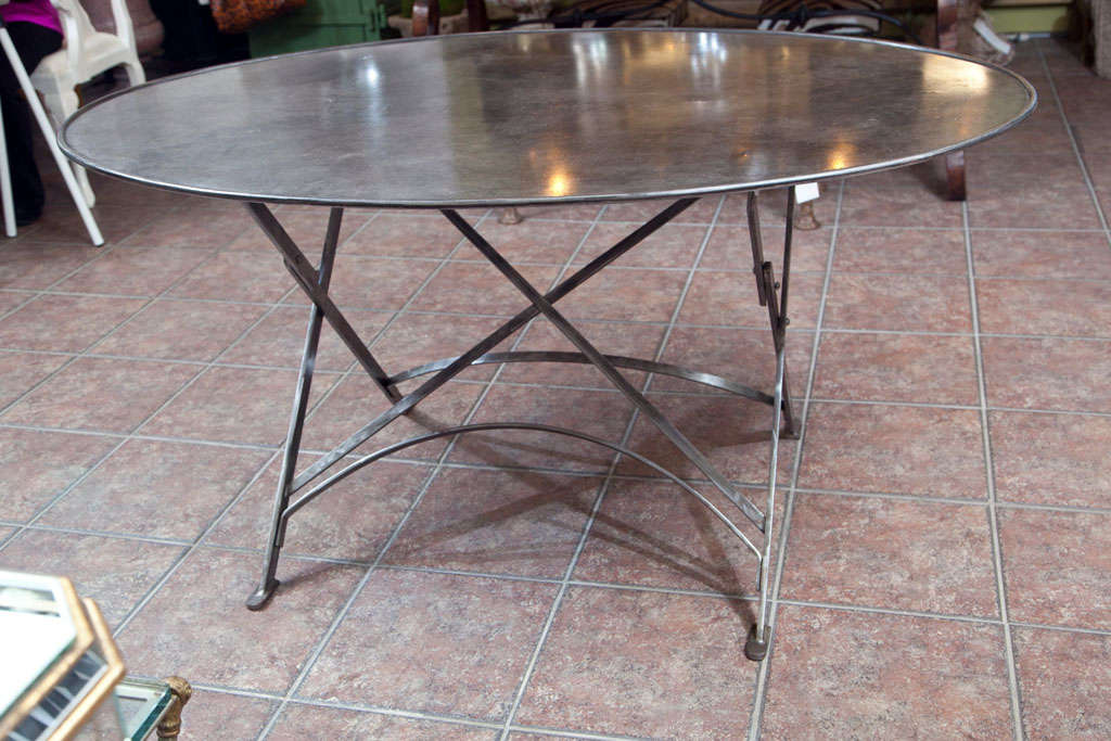 Imported from France folding metal tables, wrought iron campaign style, oval shape. Seats 4 to 6