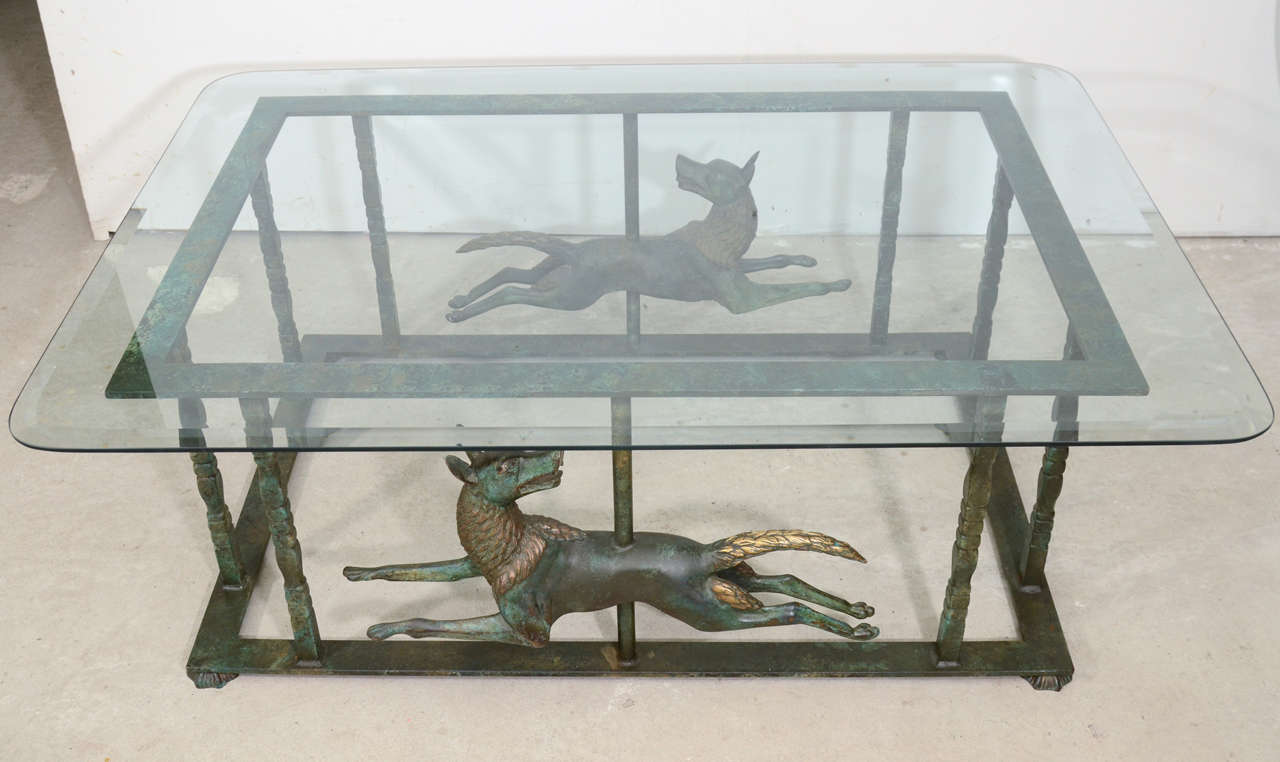 Stunning continental iron wrought coffee table with two cast bronze dogs statues with it's original patina.