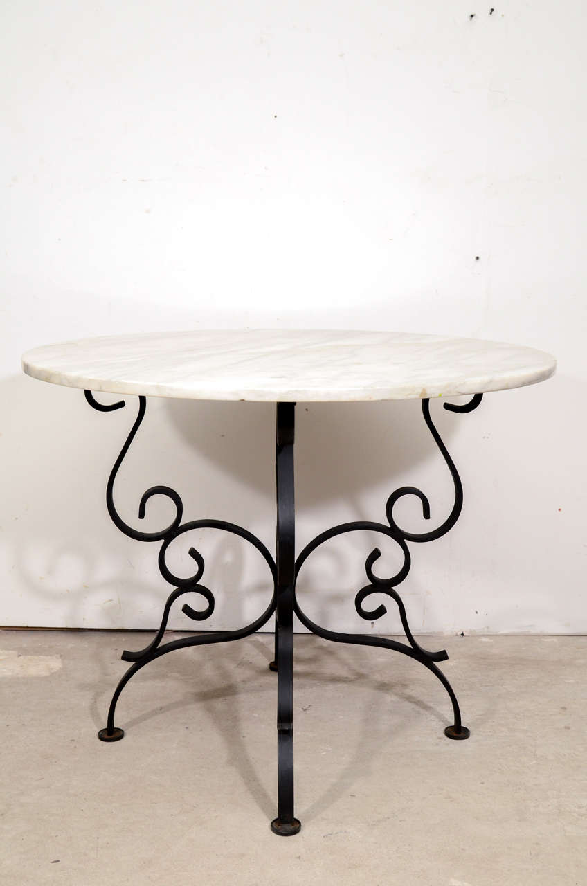 Beautiful French iron wrought center table with circular marble on the top.